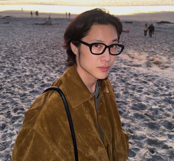 Leon memakai kacamata di pantai saat sunset
